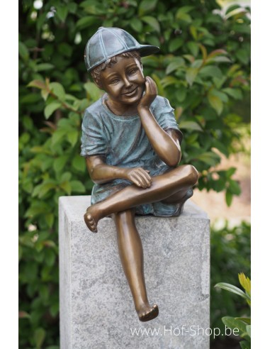 Zittende jongen met pet - bronzen beeld